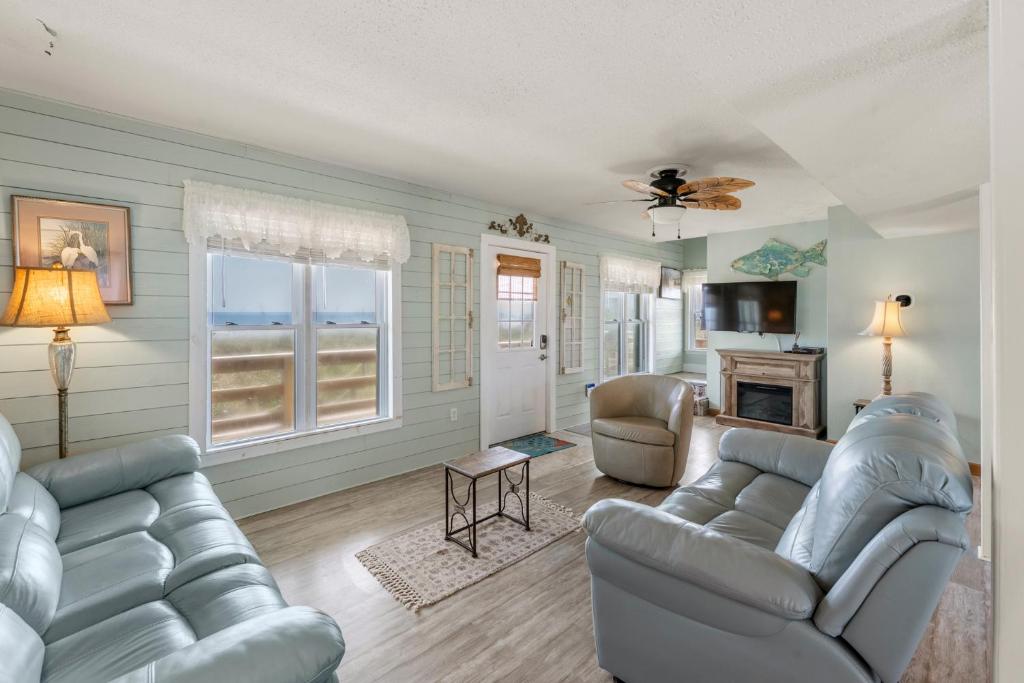 a living room with two couches and a fireplace at Rose Cottage in Rodanthe