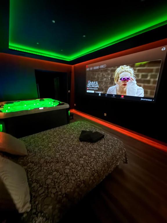 a bedroom with a bed and a tv with green lights at Le secret in Nîmes