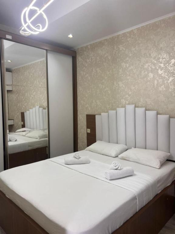 a bedroom with a large white bed with a mirror at Comfort class apartment 10 in Kutaisi