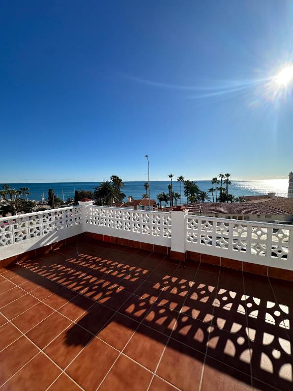 a balcony with a white fence and the beach at La Chinita in Nerja