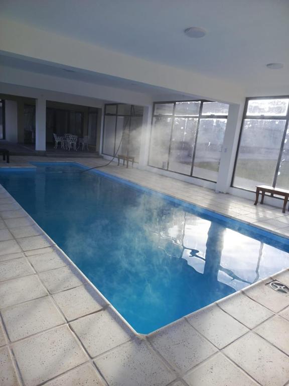 a large swimming pool with blue water in a building at Hotel Cuesta de Miranda in Villa Unión