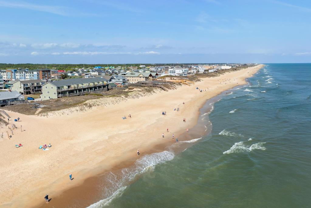 Una vista aérea de una playa con gente en ella. en Seawalk Condos, en Kill Devil Hills