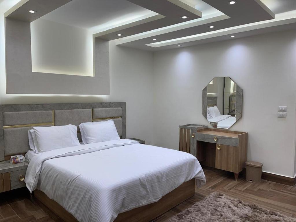 a bedroom with a large bed and a mirror at Dar Residence - Madinaty B12 - U1 - 3 BR - New Cairo in Madinaty