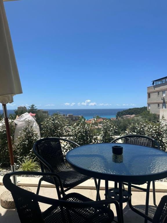 a table and chairs on a patio with a view of the ocean at Nicks sea view appartement II in Petrovac na Moru