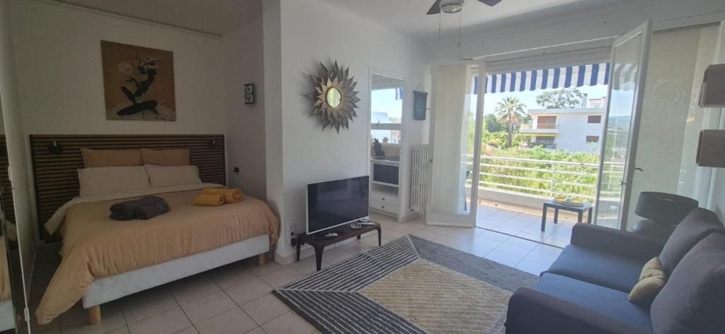 a bedroom with a bed and a tv and a couch at Cannes Studio near Croisette Plage in Cannes