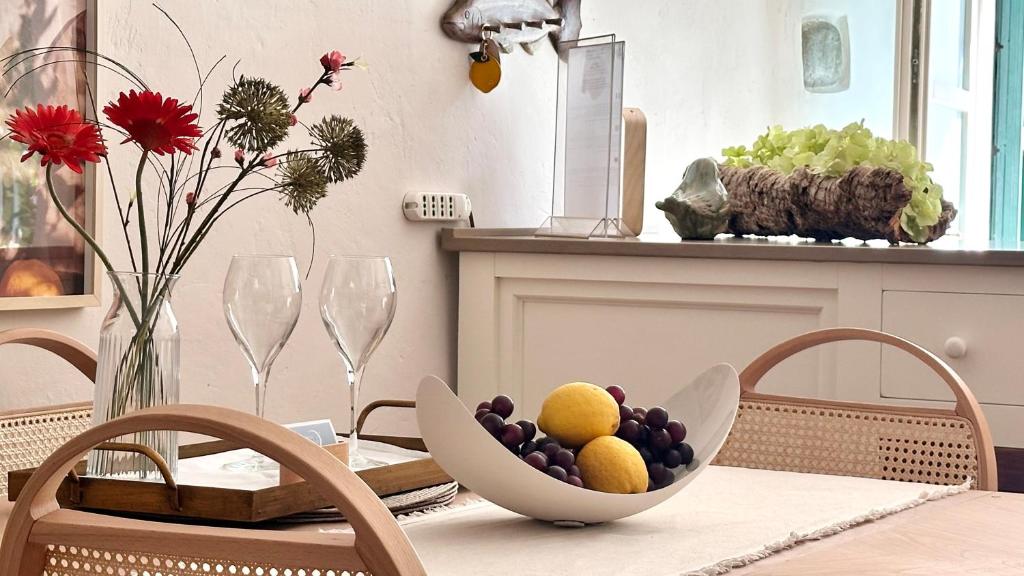 a table with a bowl of fruit on top of it at Borgo dei Sogni - Deluxe Apartment with Terrace - Lago di Garda in San Felice del Benaco