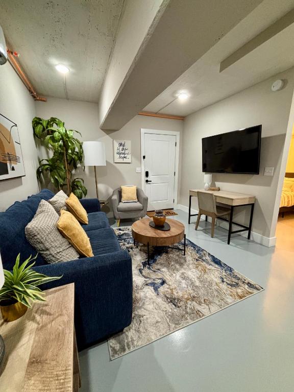 a living room with a blue couch and a tv at The Monarch Unit 8 in Huntsville