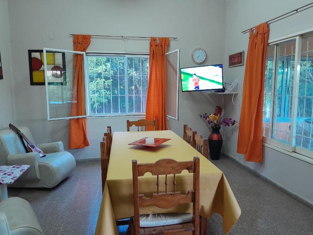 Una sala de estar con una mesa y un televisor. en Casa ideal Pileta, Quincho y Patio Enorme, en Bialet Massé