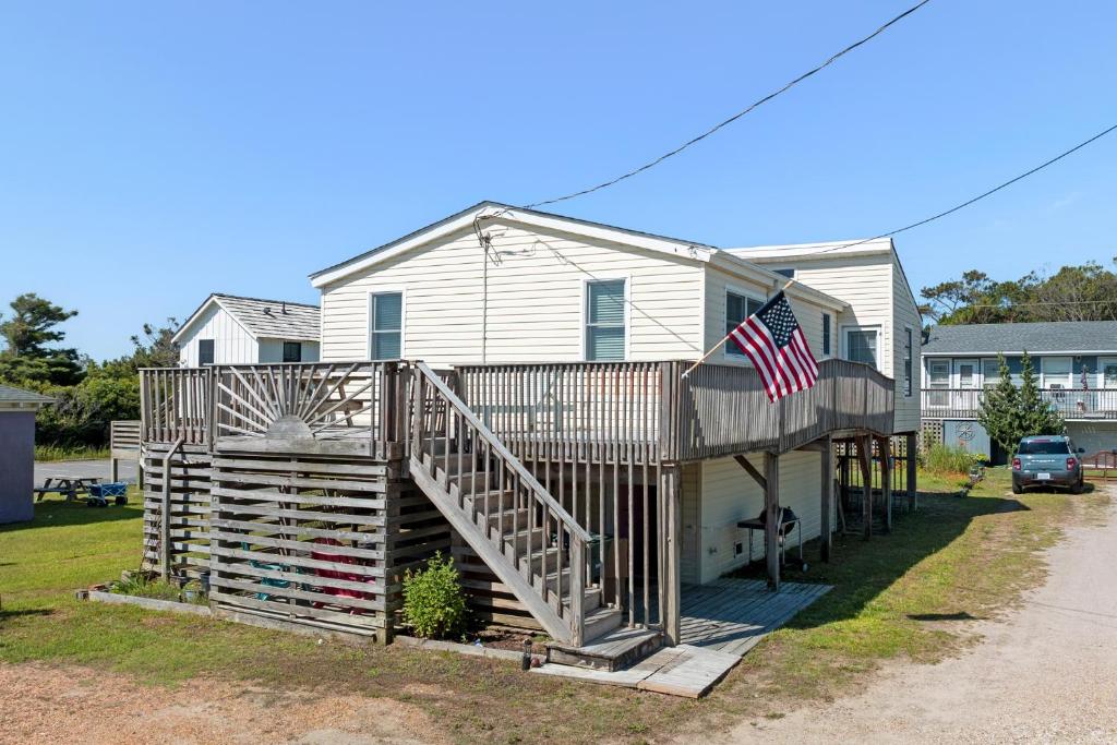 a house with a porch with an american flag on it at Seasons in the Sun in Nags Head