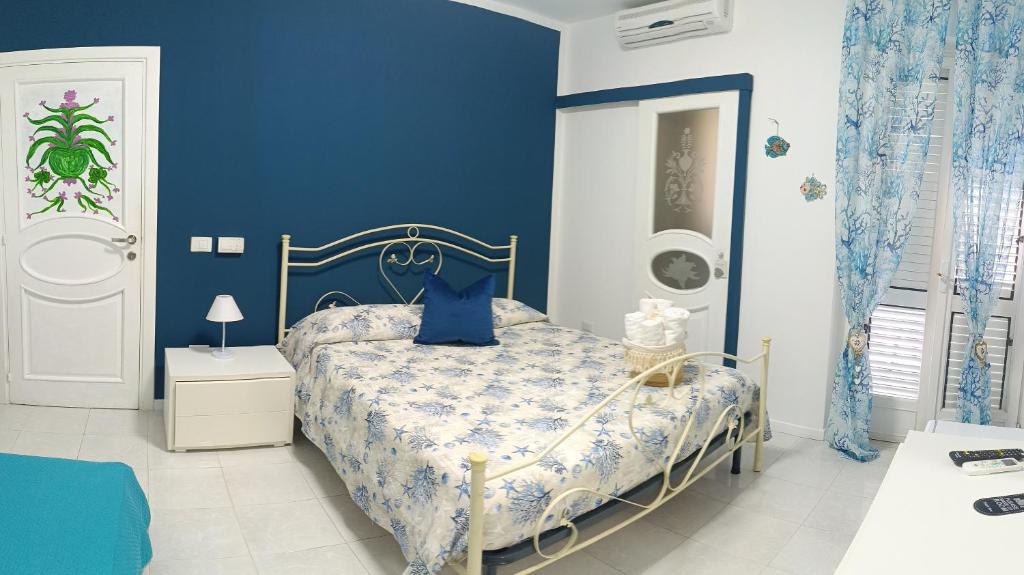 Un dormitorio azul con una cama con una pared azul. en Torre Agada, en Agropoli