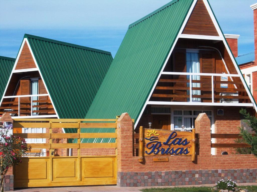 ein Haus mit einem grünen Dach und einem Schild in der Unterkunft Cabañas Las Brisas in Puerto Madryn