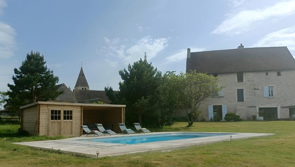 a swimming pool in front of a house at La Ferme Aux Arts in Beaumont-sur-Grosne