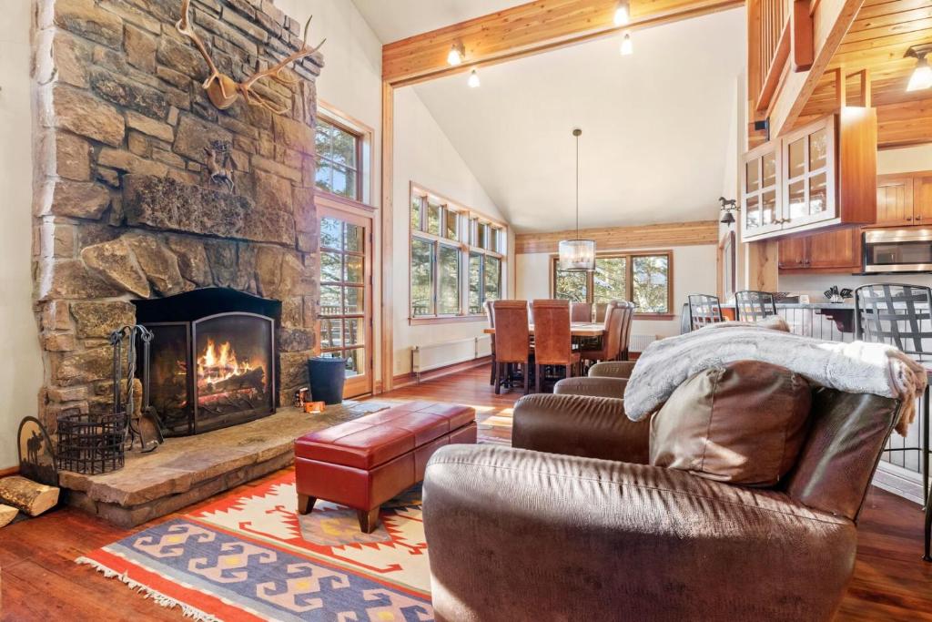 a living room with a large stone fireplace at RMR: The Village House in Teton Village in Teton Village
