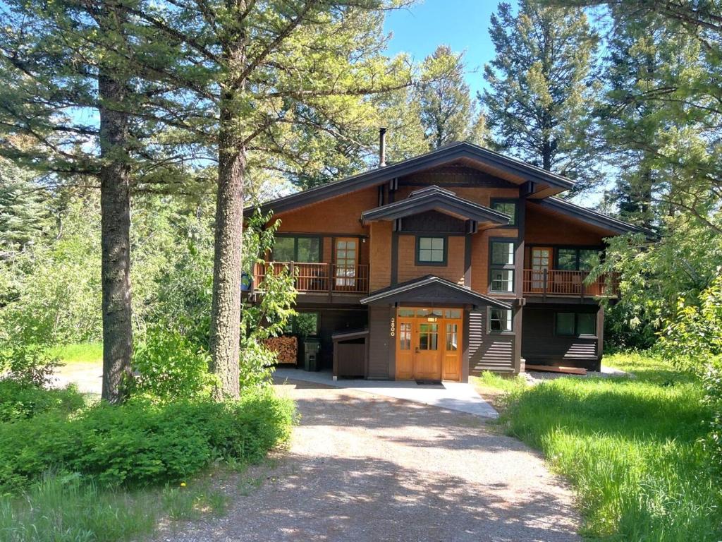 a large wooden house with a driveway in front at RMR: The Village House in Teton Village in Teton Village