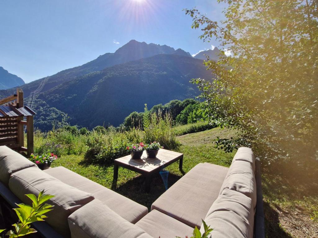 un canapé et une table avec vue sur une montagne dans l'établissement Chalet Amuse, à Vaujany