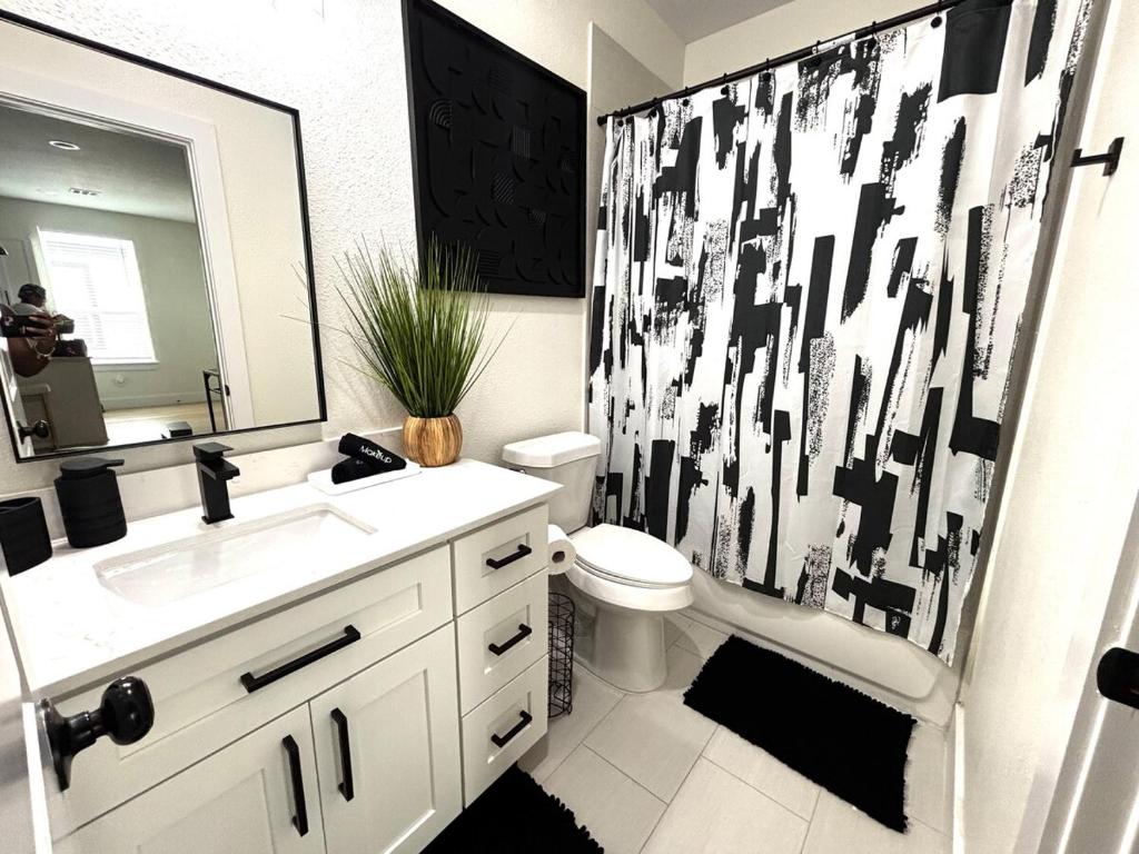 a bathroom with a black and white shower curtain at Houston Luxury 2bd Apartment in Houston