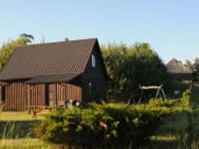 a large wooden house in the middle of a field at Zagroda z Antonówką in Szypliszki