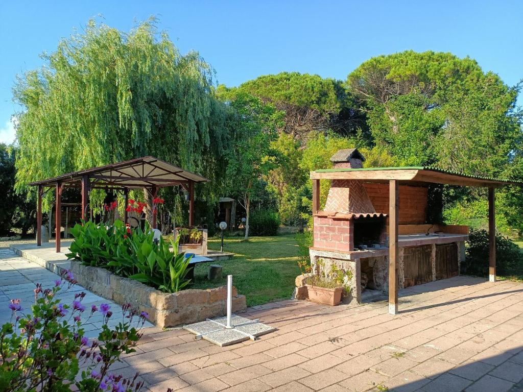 a garden with a brick fireplace and a gazebo at IL Noce ALGHERO in Santa Maria la Palma