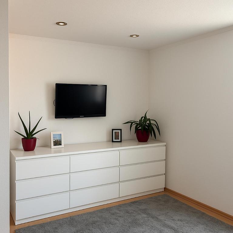 a living room with a tv on a white wall at City Center Room with a view in Niederdorla