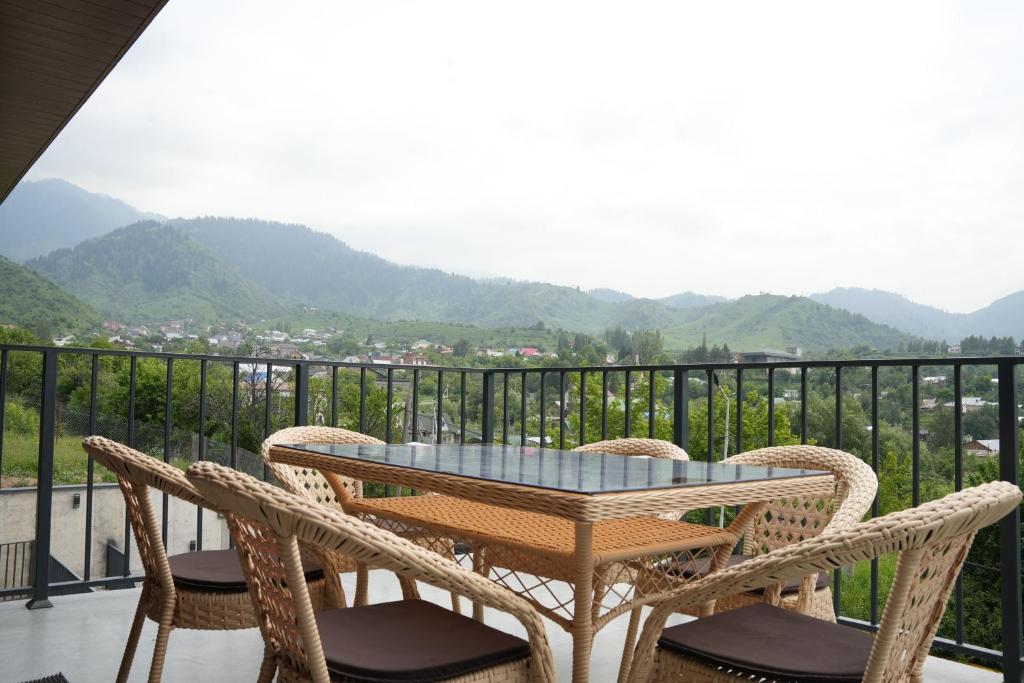 ein Tisch und Stühle auf einem Balkon mit Aussicht in der Unterkunft RODNIK guesthouse in Besqaynar