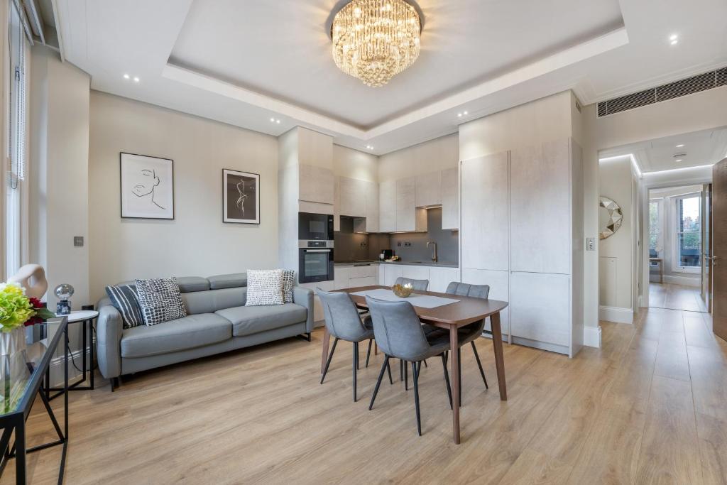a living room with a couch and a table and chairs at LuxLet Apartments - Heart of Hampstead, London in London