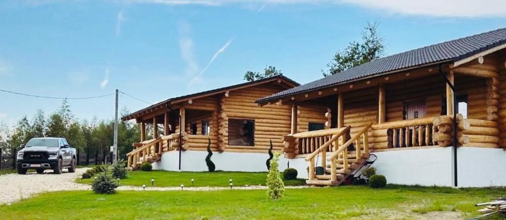 eine Blockhütte mit einem davor geparkten Auto in der Unterkunft Sub Stele Chalets in Holbav