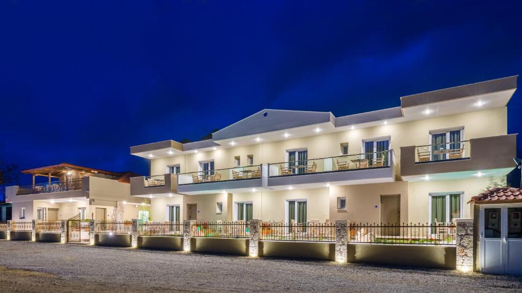 Lagaria Luxury Rooms & Apartments في أسبروبالتا: مبنى أبيض كبير في الليل