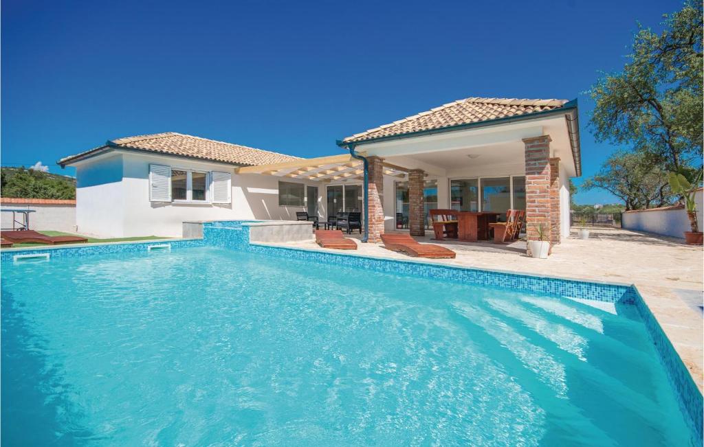 une piscine devant une maison dans l'établissement Cozy Home In Radosinovci With Kitchen, à Radošinovac