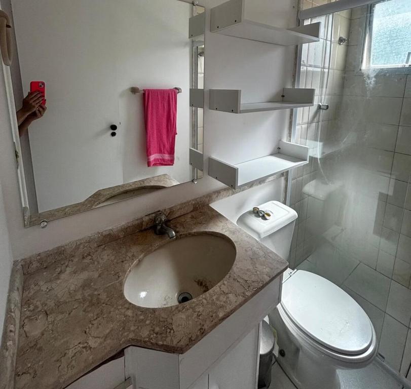 une salle de bain avec un lavabo, des toilettes et un miroir dans l'établissement Morumbi Stadium Apartment, à Água Boa