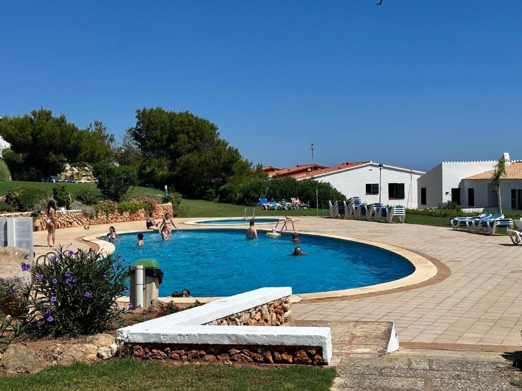 un grupo de personas jugando en una piscina en Costa Arenal 112 by SOM Menorca, en Arenal d'en Castell