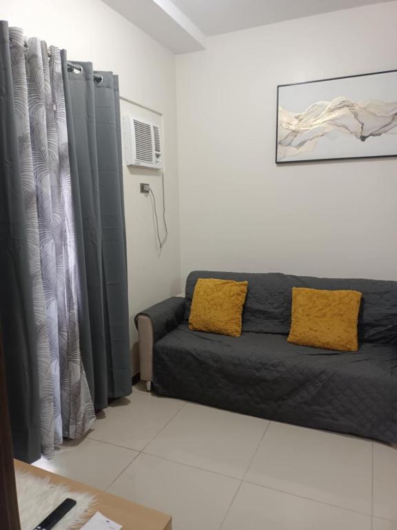 a living room with a couch and gray curtains at Robinsons Galleria Tower 2 - Nice Place in Cebu City