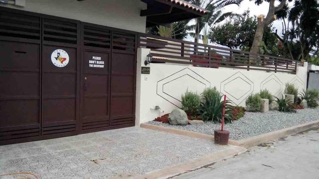 a garage with two brown doors and some plants at Fuji sleeps 16-18 in Angeles
