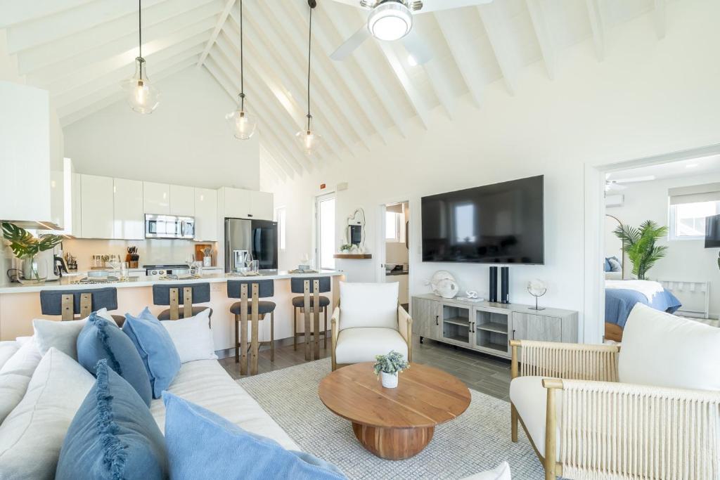 サン・ペドロにあるCanalfront Retreat and Pool Club at Mahogany Bayの白いソファとテーブルのあるリビングルーム