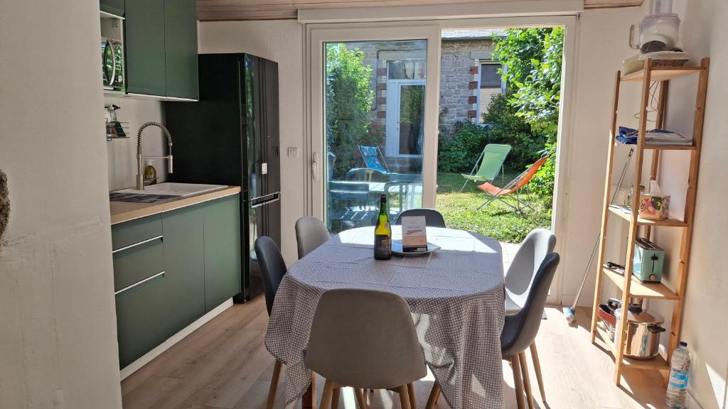 a kitchen and dining room with a table and chairs at Les Pâquerettes in Dinan