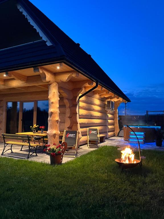 a log cabin with a fire pit in the yard at Góralskie Domki u Topora in Czarny Dunajec