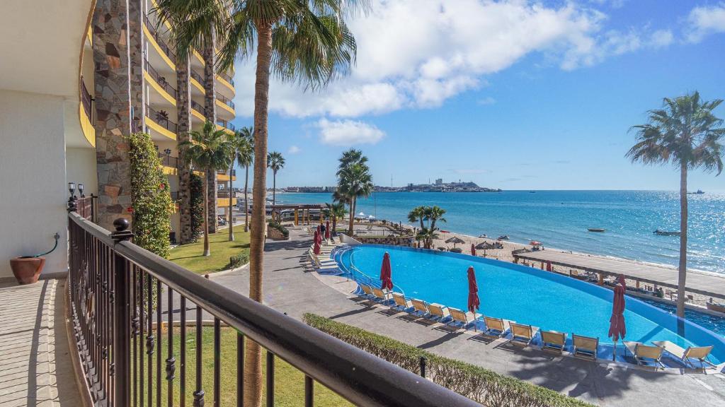 a balcony with a view of the ocean and a swimming pool at The Great Escape Modern Oceanfront in Puerto Peñasco