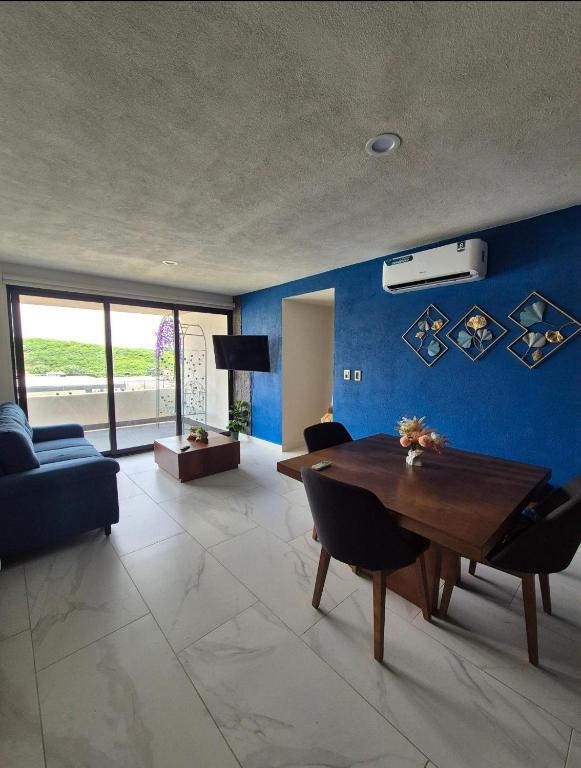 a living room with a table and a blue wall at Casa Sayil in Alpuyeca