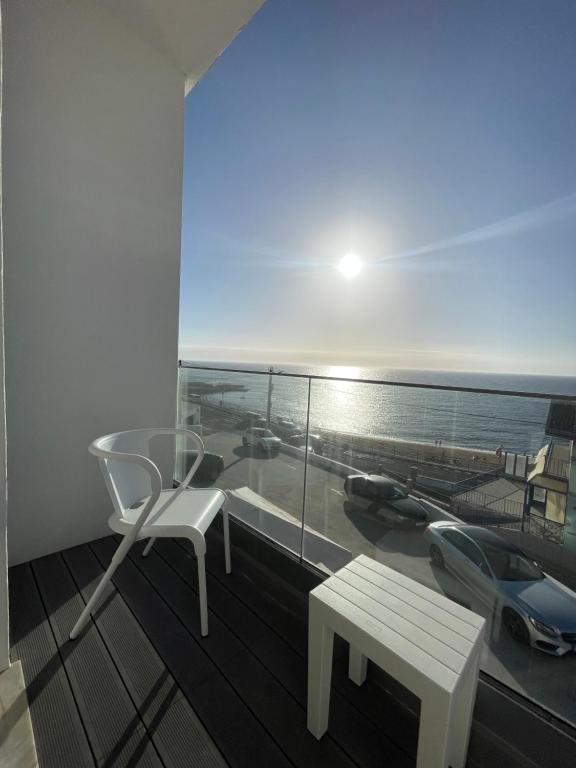 a balcony with a table and a bench and the ocean at Beach Residence Mar do Norte in Ribamar