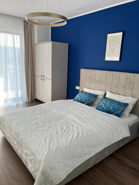 a blue bedroom with a large bed with blue walls at B&B ApartHotel in Bistriţa