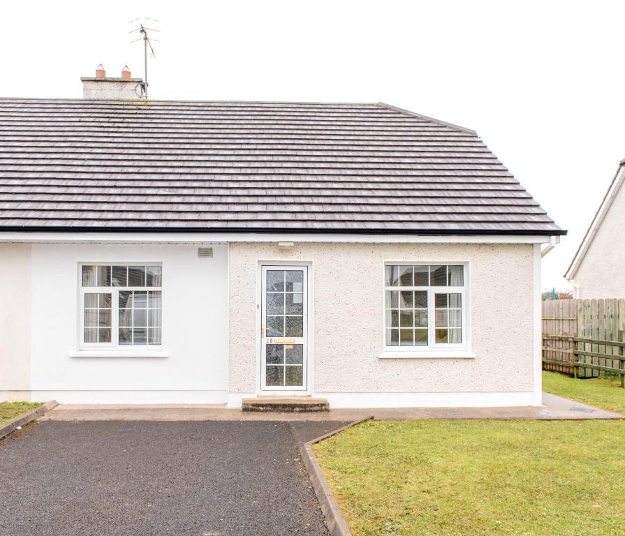 a white house with a black roof at Bunhovil - 2 Bedroom Bungalow in Bundoran