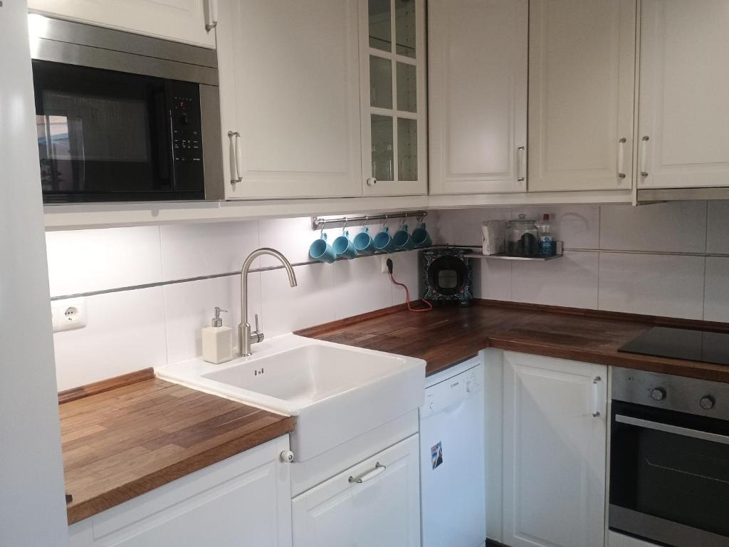 a white kitchen with a sink and a microwave at Family Vacation in Málaga