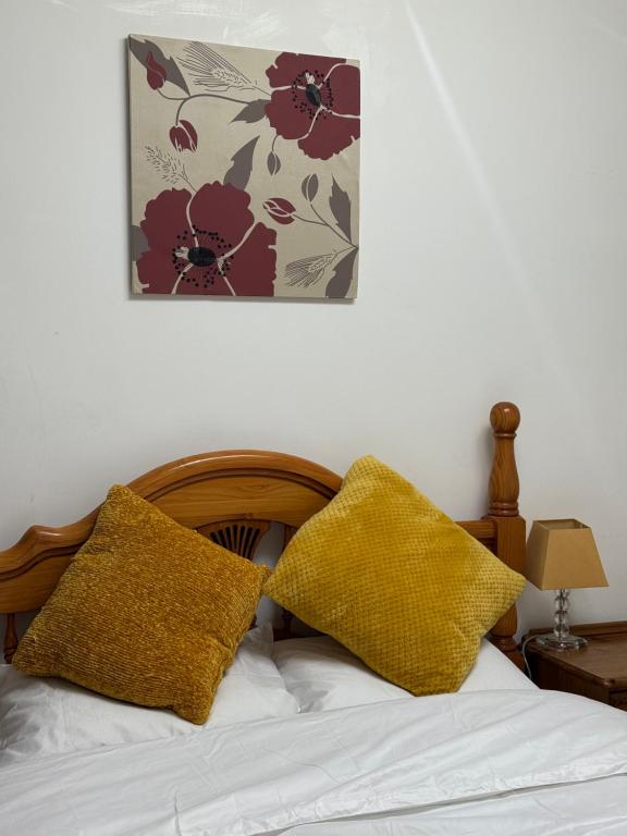 a bedroom with a bed with two pillows on it at Wellesley Apartments in Great Clacton