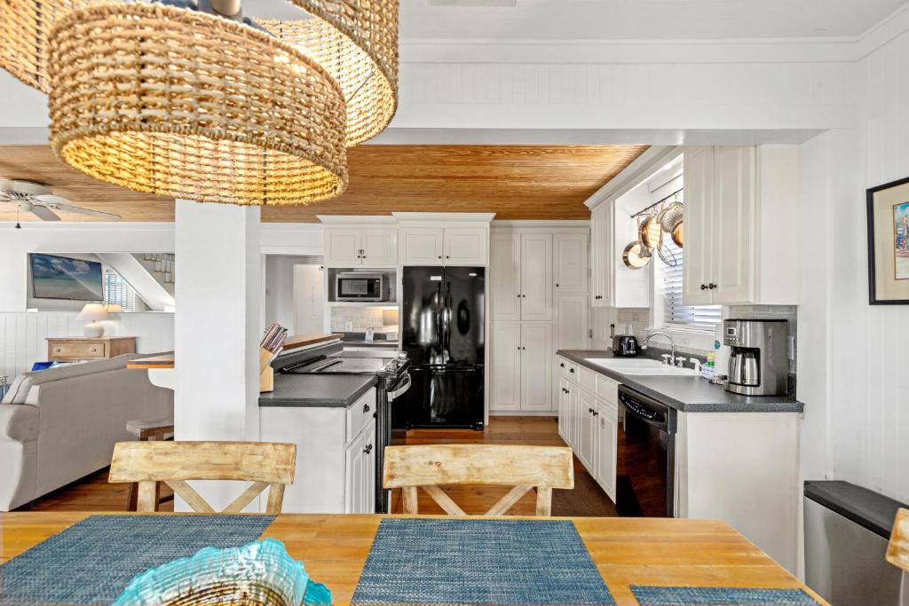 une cuisine avec des armoires blanches et un lustre dans l'établissement Cute Beach Cottage Steps to the Beach! Panama City Beach, FL!, à Laguna Beach