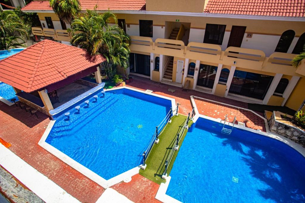 - une vue sur la piscine en face d'un bâtiment dans l'établissement Hotel Vista Caribe Playa, à Playa del Carmen