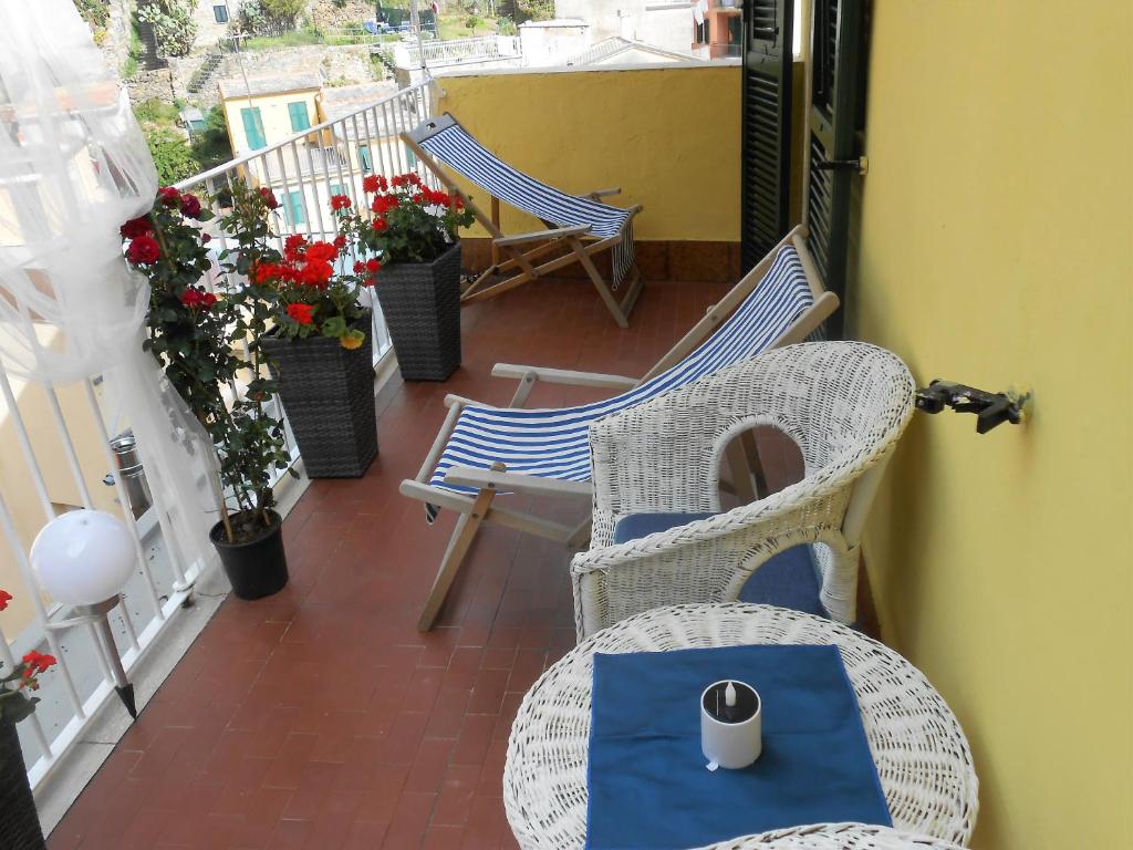 a balcony with chairs and a table with a cup on it at The Sunrise in Riomaggiore