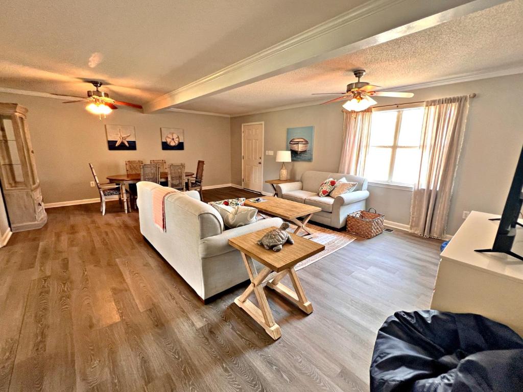 a living room with a couch and a table at Oakridge Cottage in Orange Beach