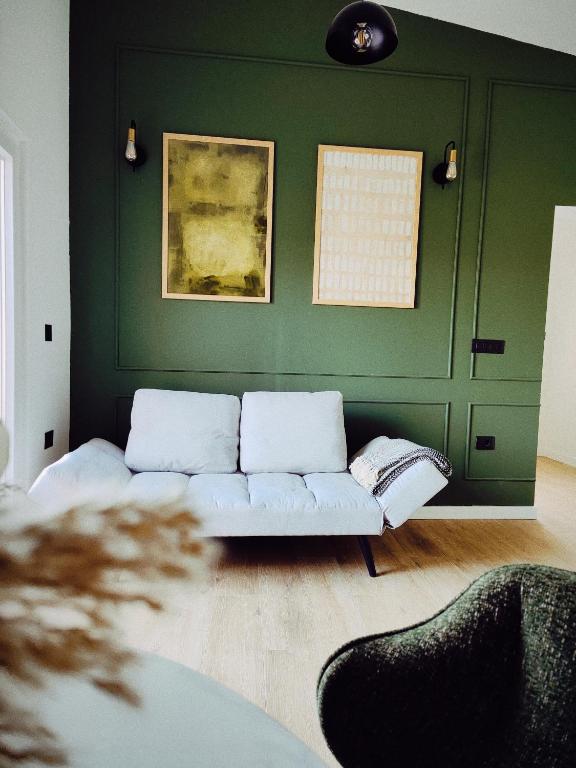 a living room with a couch and a green wall at Antoni Apartment in Lastovo