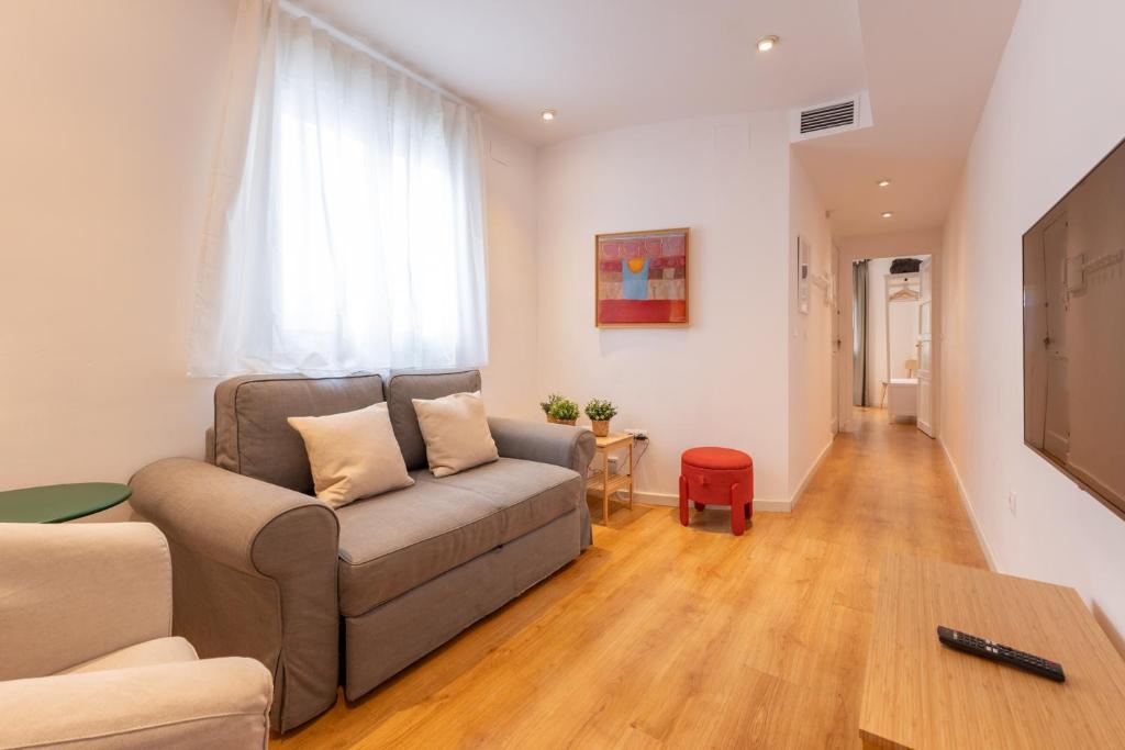 una sala de estar con un sofá y una mesa en Charming 2 bedroom Apartment at Virgen de Begoña, en Sevilla