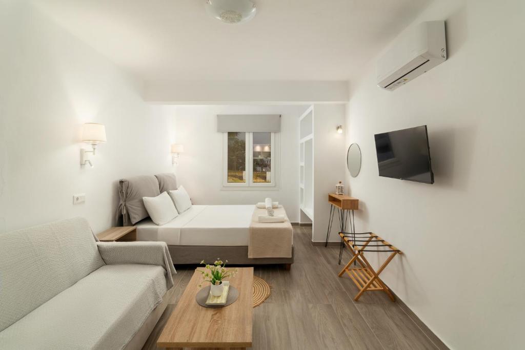 a white living room with a bed and a couch at DK Square in Andros