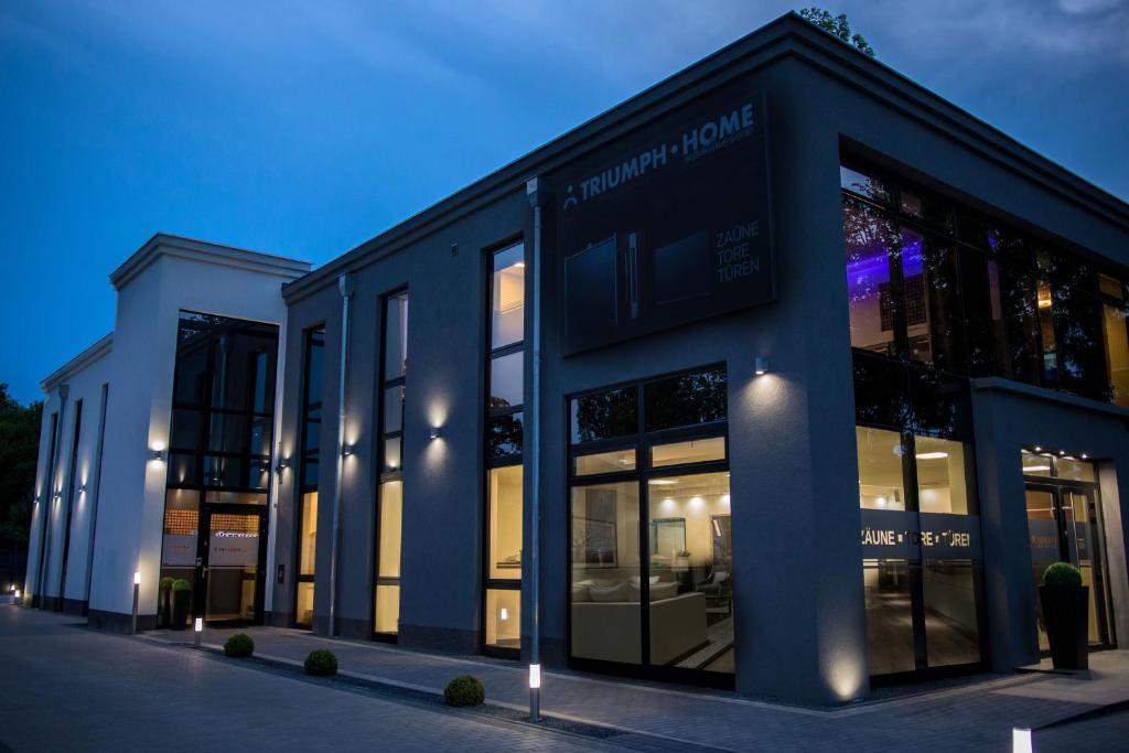 a large building with glass windows on a street at Triumph Inn Pension in Rangsdorf